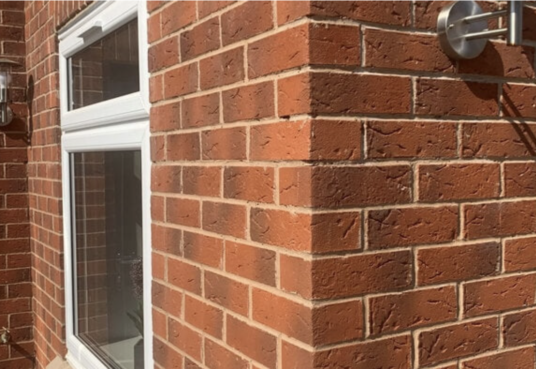 Red bricks on building corner with window